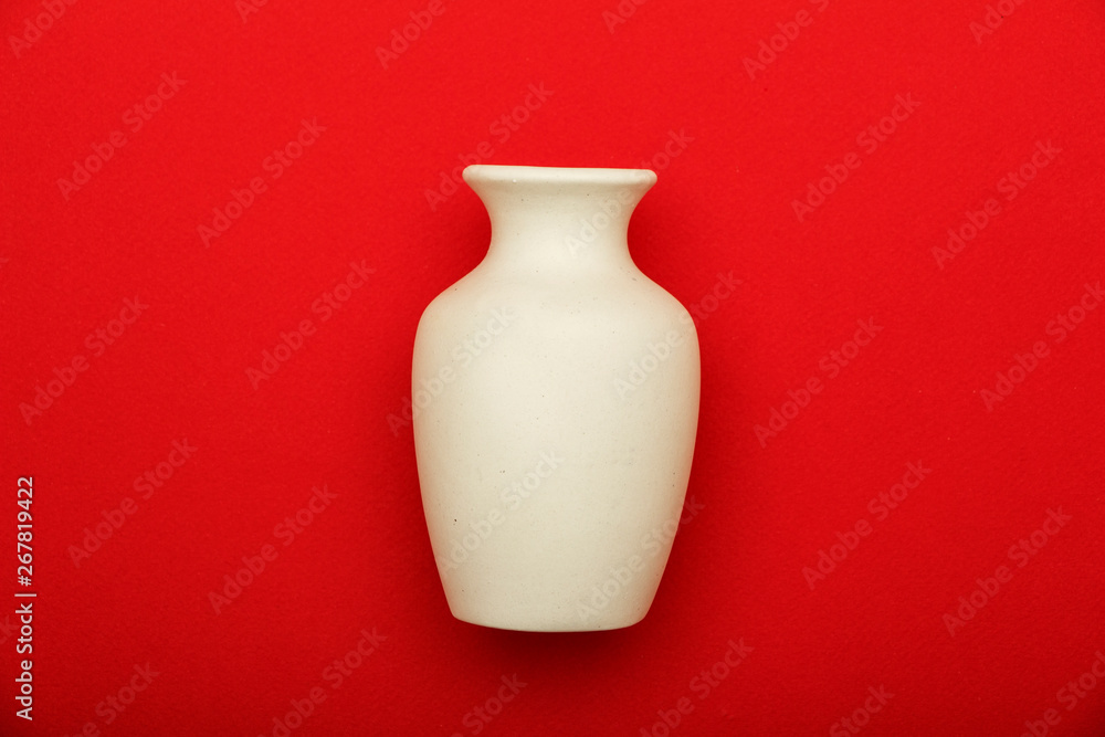 Pottery, vase, white clay jug isolated on red background. Pottery mockup made from white clay on a red background. Pottery, vase, white clay jug isolated on red background. Pottery mockup made from white clay on a red background.