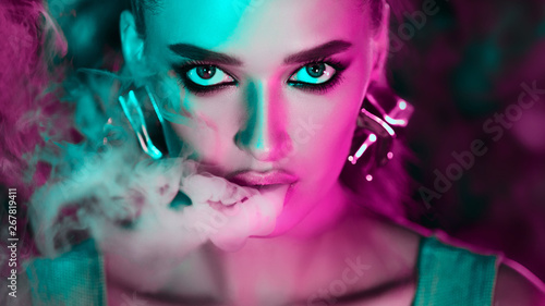 Smoking E-Cigarette. Woman in green and pink neon lights