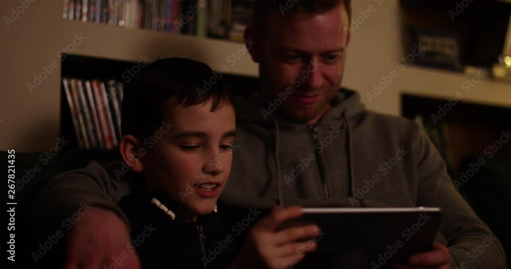4k, Father and son enjoying a movie on a tablet. 4k, Father and son enjoying a movie on a tablet.
