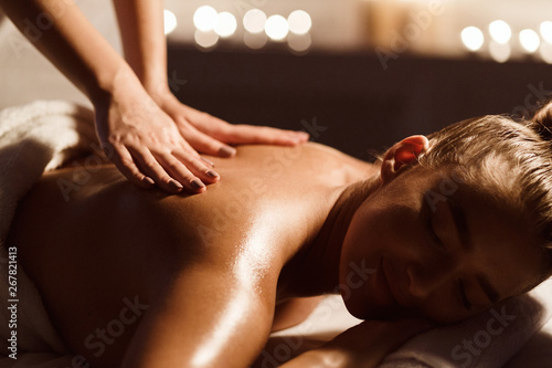 Back Massage. Woman Relaxing In Atmospheric Spa Salon