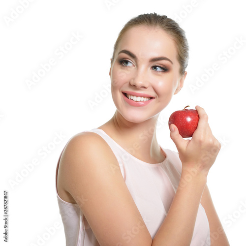 Beauty female portrait. Young attractive woman posing at studio with apple over white background. Beautiful girl with perfect smile. Model with perfect make-up