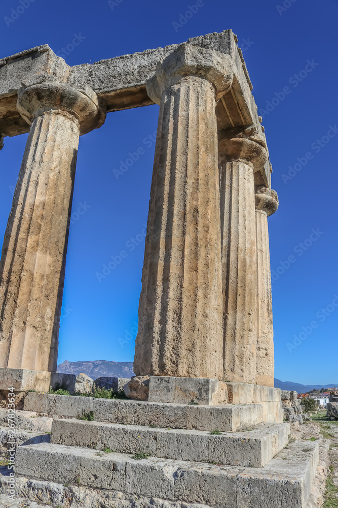 Pillars of Temple of Apollo in Ancient Corinth on the Peloponnese Peninsula Greece - looking up at diminishing perspective and deep blue sky
