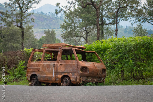 Abandoned van parked in side of hill road in a foggy bright day