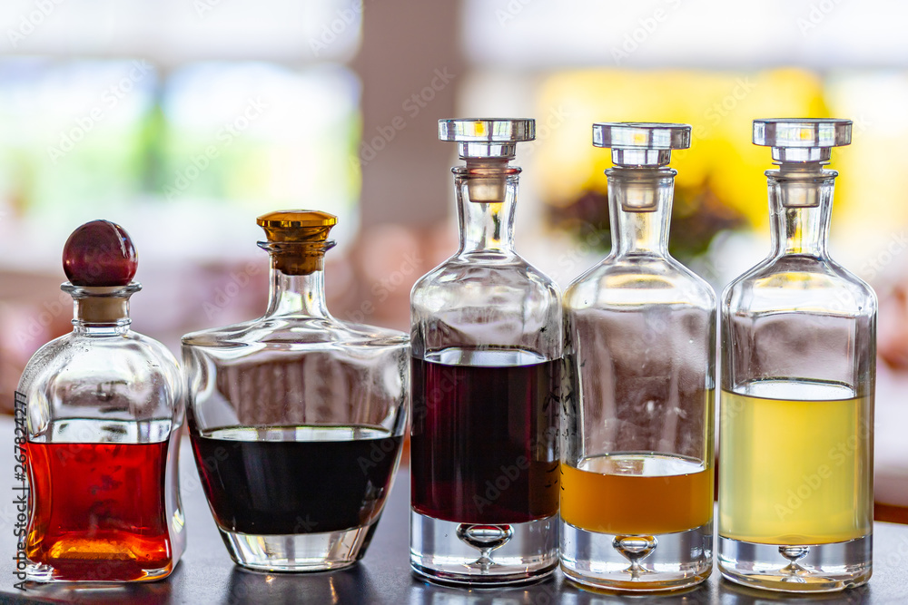 Set of bottles with home made tasty liqueurs inside.