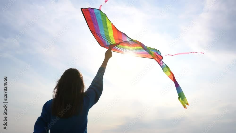 Girl with a kite in her hand against the backdrop of a sunny sky Girl with a kite in her hand against the backdrop of a sunny sky