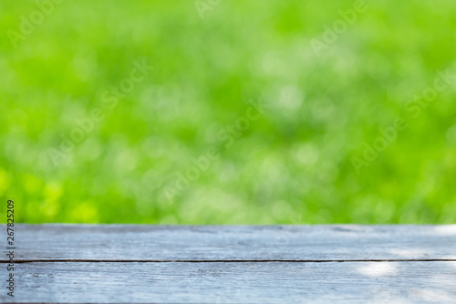Empty wooden table over bokeh natural background