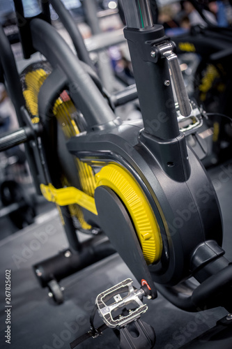 Close up of black and yellow sport bicycle in the gym for training.