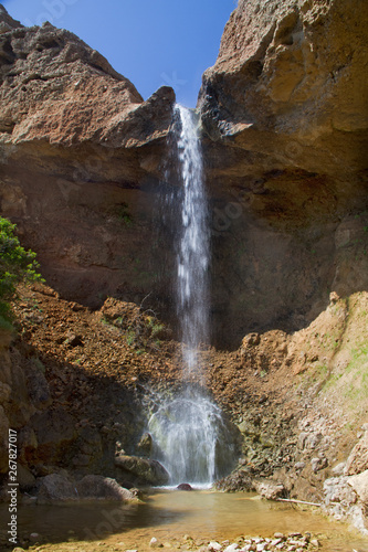 Small waterfall splashing down in a small pool in a rocky landcape