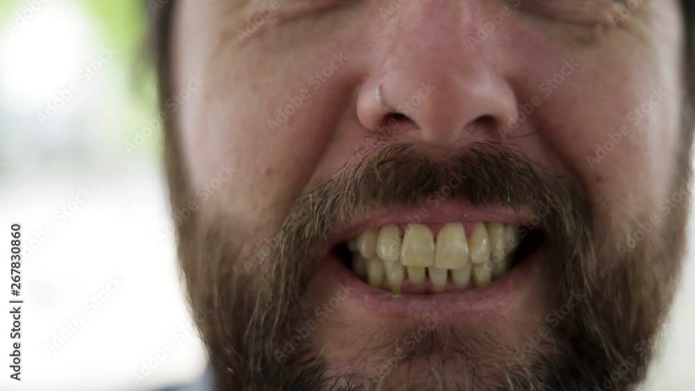 Toothy smile of bearded mid adult man. Close-up partial view of cheerful bearded middle aged man smiling outdoor. Emotion concept Toothy smile of bearded mid adult man. Close-up partial view of cheerful bearded middle aged man smiling outdoor. Emotion concept