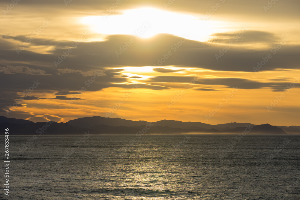 Obraz premium Clouds during golden sunset in basque country