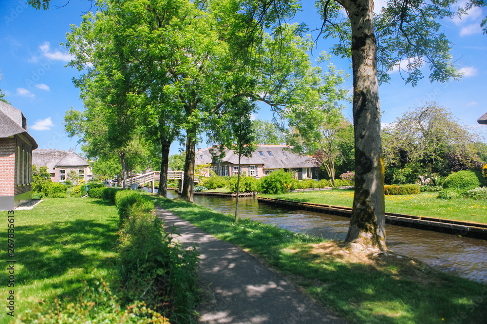 View of famous typical Dutch village Giethoorn with canals in the province of 'Overijssel. The beautiful Traditional Dutch House and gardening city is know as View of famous typical Dutch village Giethoorn with canals in the province of 'Overijssel. The beautiful Traditional Dutch House and gardening city is know as