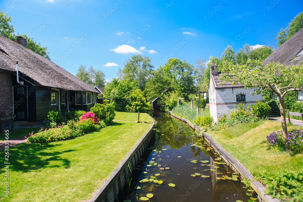 View of famous typical Dutch village Giethoorn with canals in the province of 'Overijssel. The beautiful Traditional Dutch House and gardening city is know as 