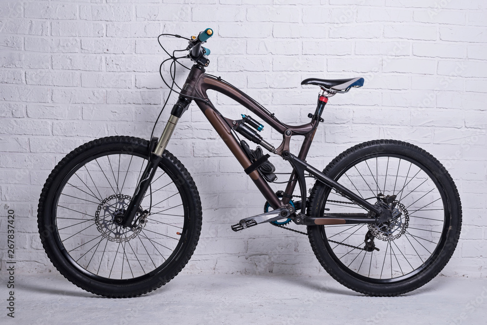 Full suspension mountain bike on a brick wall background. Full suspension mountain bike on a brick wall background.