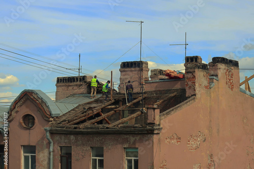 People repairing the roof of an old building 