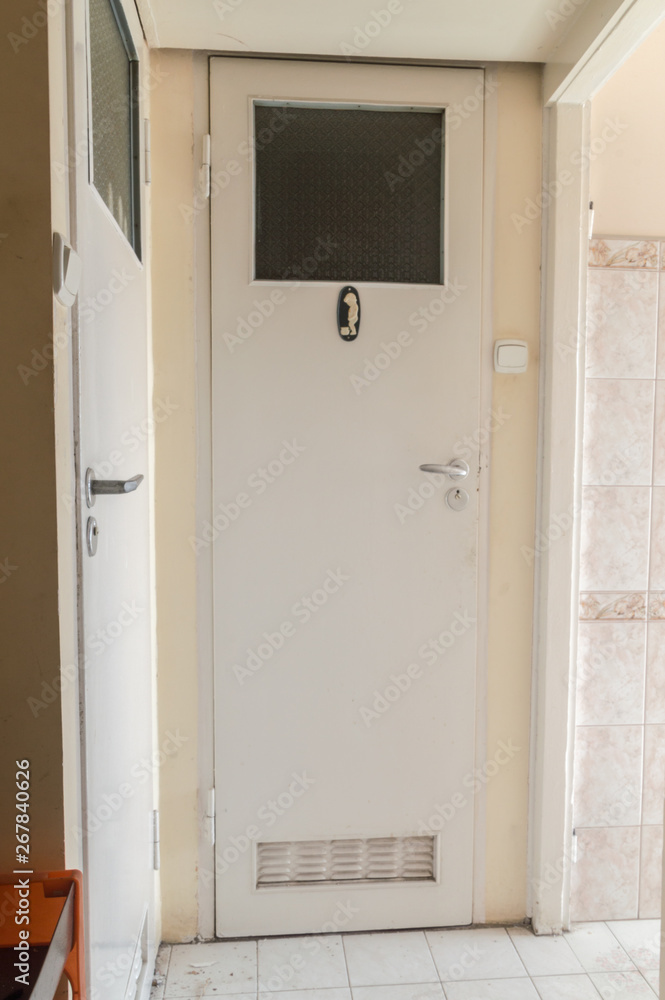 Old white wooden interior door to WC. Old white wooden interior door to WC.