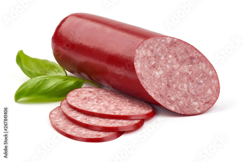 Sliced dry salami sausage stick with basil leaves, close-up, isolated on white background