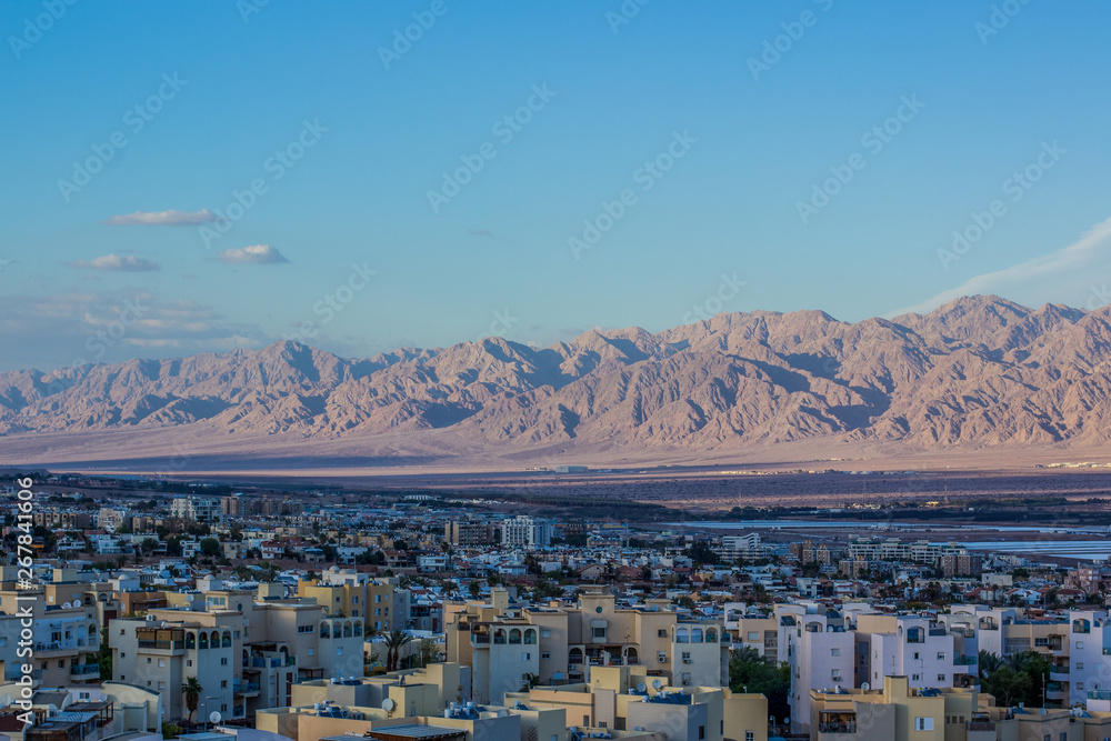 Jewish Israeli city street Eilat aerial scenic landmark photography from above with view on a buildings foreground and sand stone rocky mountain perspective horizon ridge background     - obrazy, fototapety, plakaty 