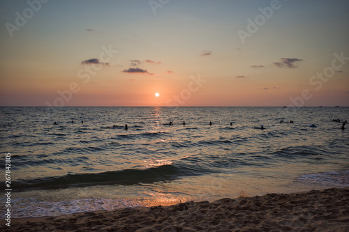 Silhouettes of swimming people on Phu Quoc island in Vietnam at sunset