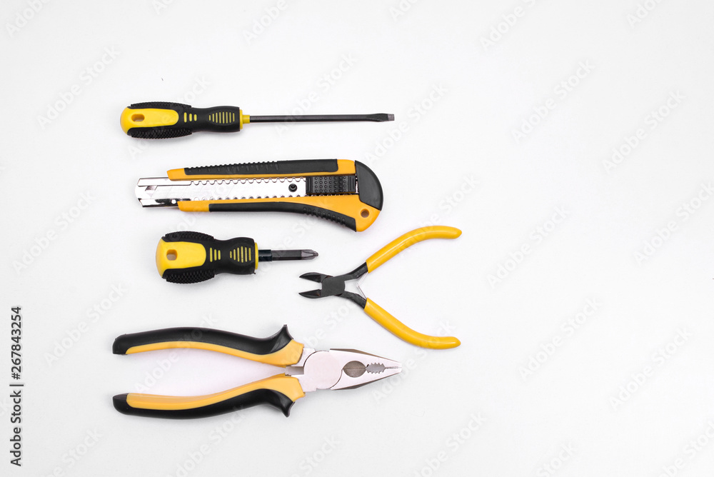 Obraz premium Black yellow tools - knife, pliers, tape measure, screwdriver, nippers on a white background. Place for text. Work inventory
