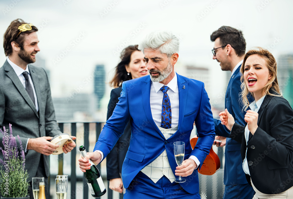 Fototapeta premium A group of joyful businesspeople having a party outdoors on roof terrace in city.