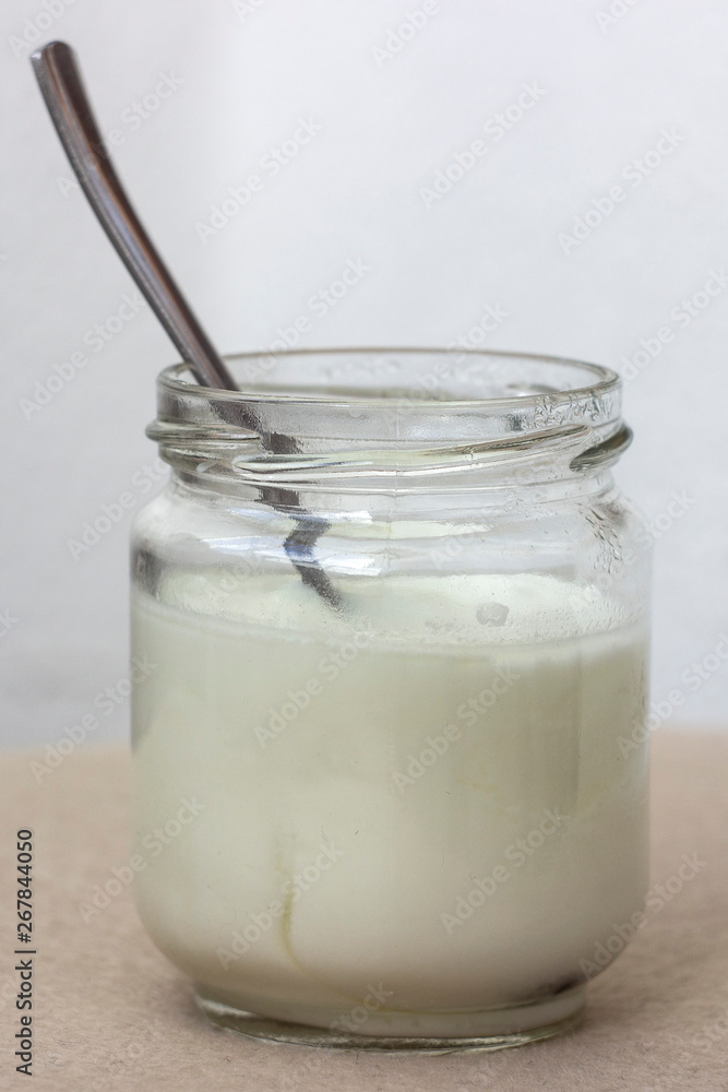 white yogurt in glass jar on table for breakfast white yogurt in glass jar on table for breakfast