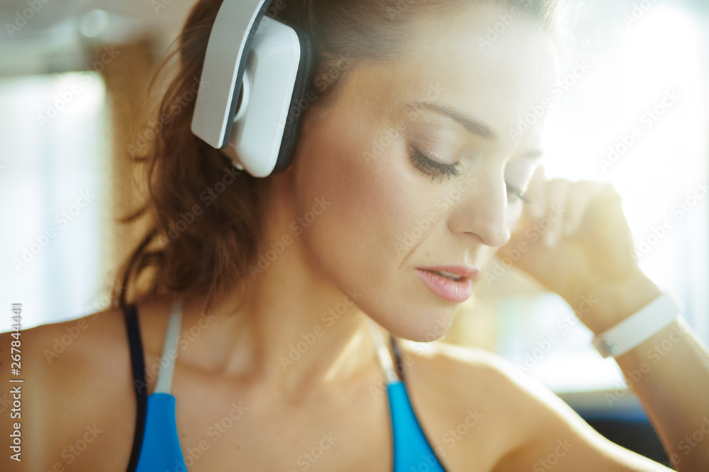 Naklejka premium woman listening to music with headphones in modern living room