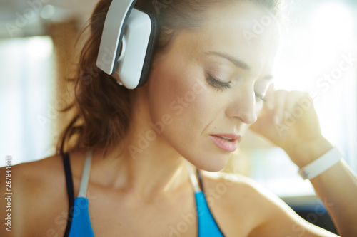 woman listening to music with headphones in modern living room