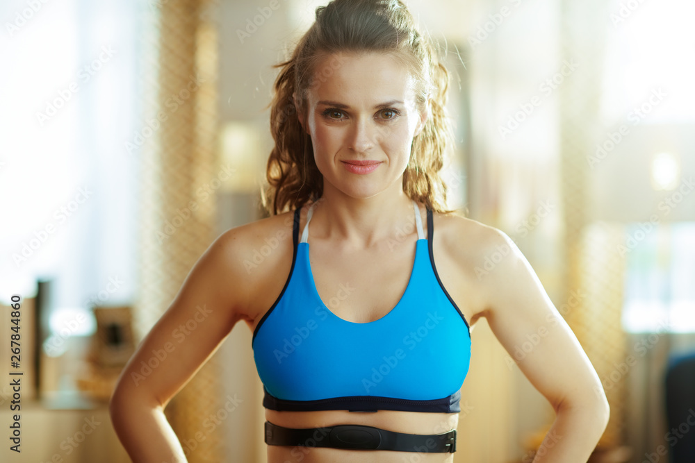 sports woman with heart rate monitor in modern living room sports woman with heart rate monitor in modern living room