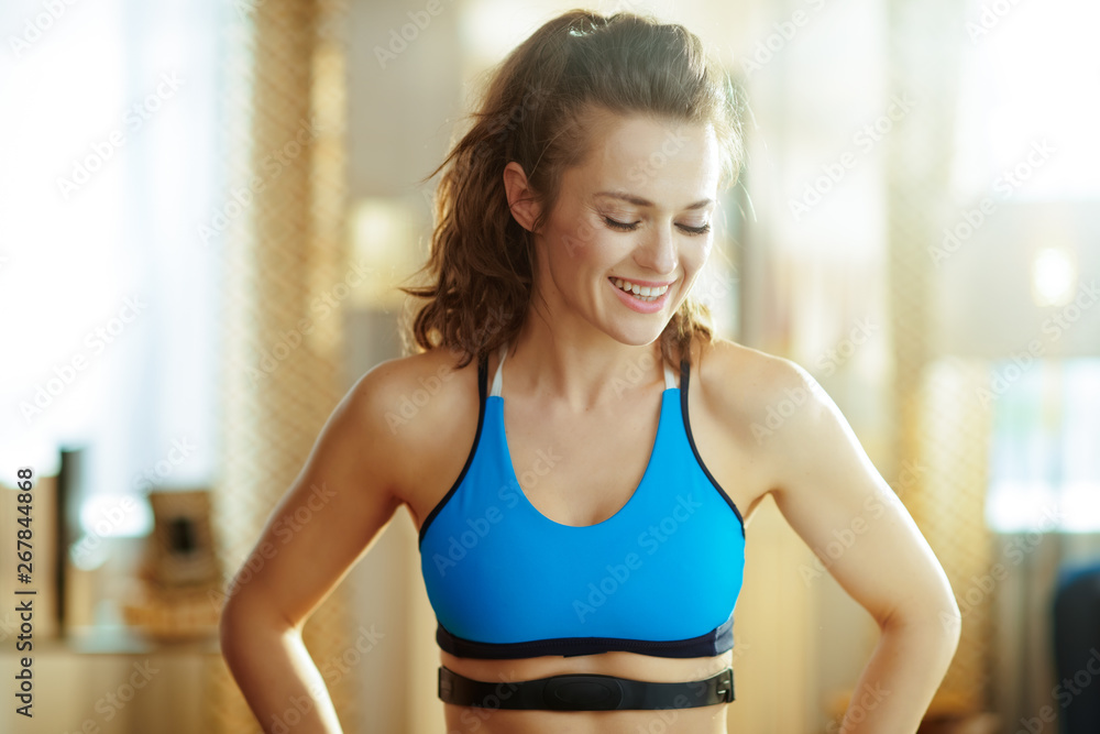 sports woman with heart rate monitor in modern living room