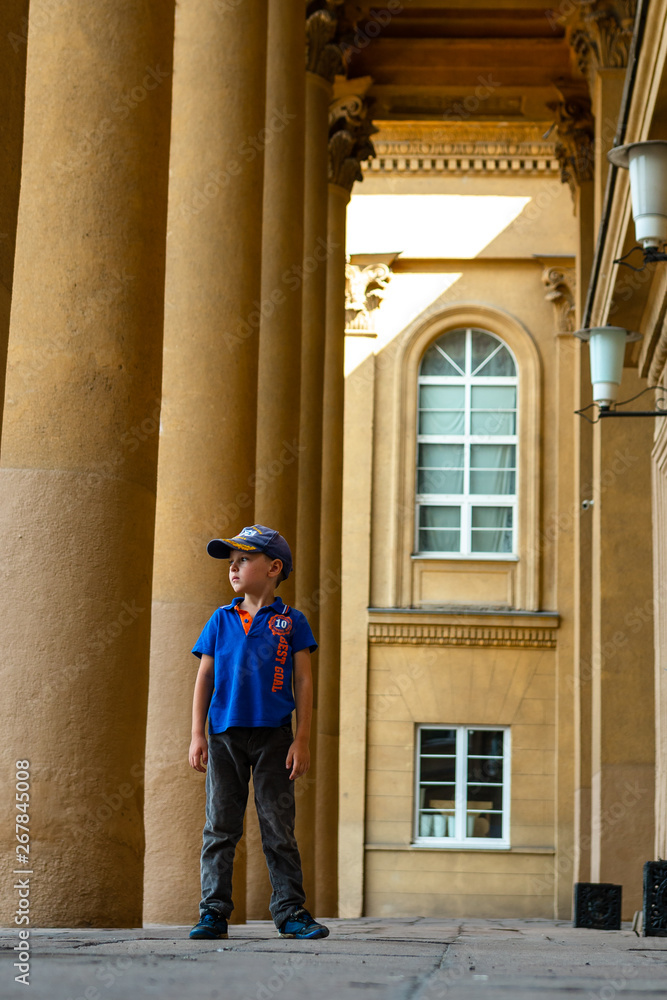 the child is standing near a column