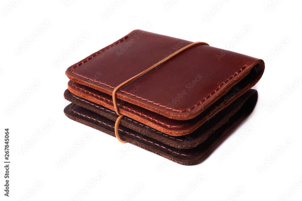 Handmade two red and brown leather cardholders with rubber band isolated on white background closeup. Stock photo of handmade luxury accessories. Handmade two red and brown leather cardholders with rubber band isolated on white background closeup. Stock photo of handmade luxury accessories.