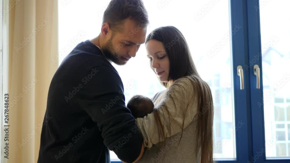 Young father man comes in maternity hospital to hold his newborn baby daughter together with his wife Young father man comes in maternity hospital to hold his newborn baby daughter together with his wife
