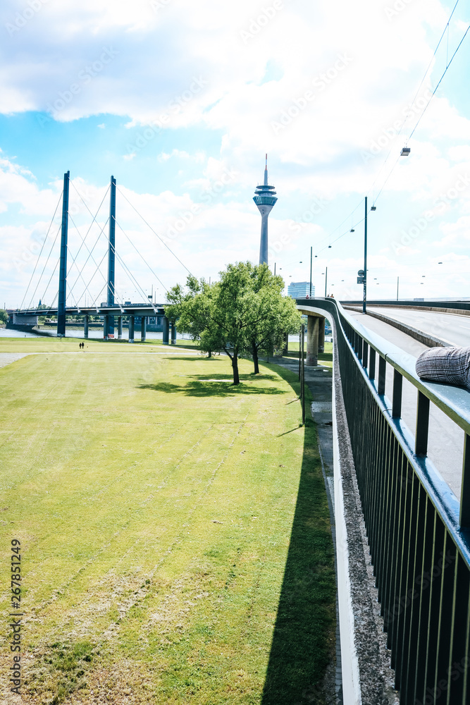 Landscape of Oberkasseler bridge and the Television Transmission Tower in Düsseldorf, Germany on a sunny summer day.