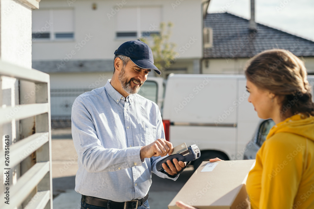 woman paying with debit card for delivery service woman paying with debit card for delivery service