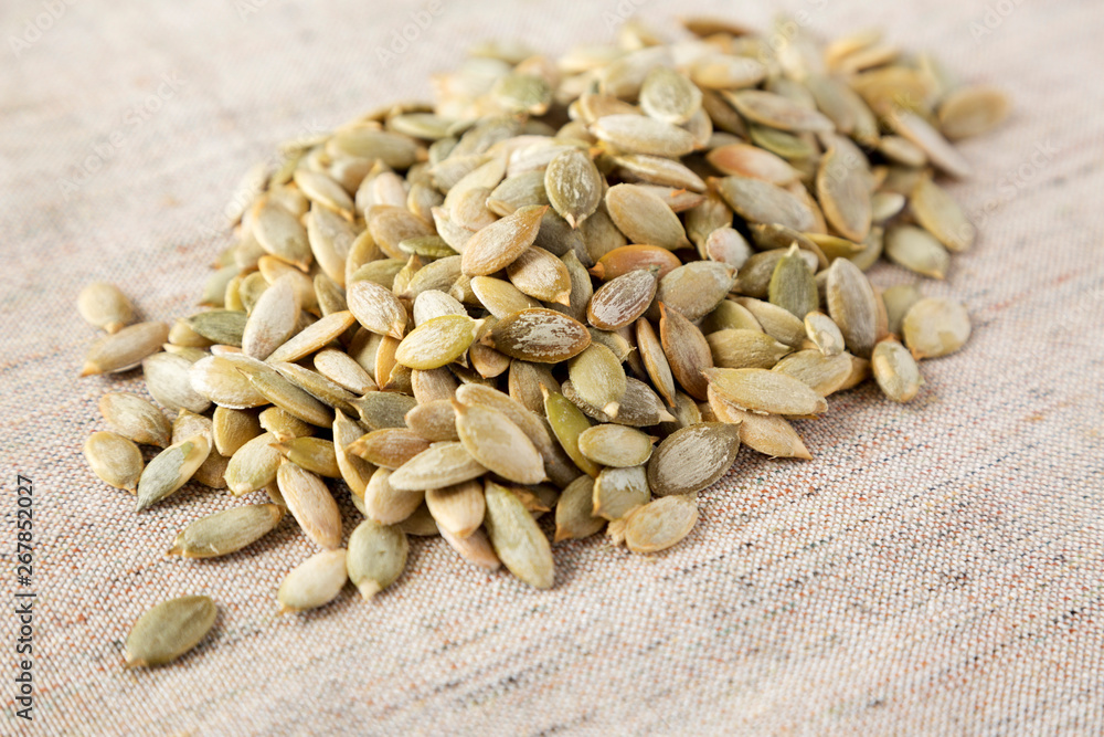 Obraz premium Roasted pumpkin seeds on cloth, side view. Close-up.