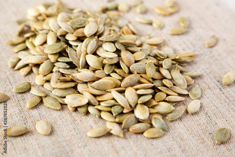 Roasted pumpkin seeds on cloth, side view. Close-up. Roasted pumpkin seeds on cloth, side view. Close-up.