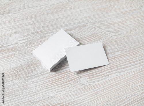 Photo of blank white business cards on light wood table background. Template for ID.