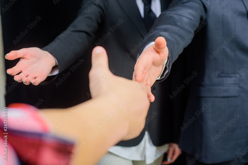Welcoming. Handshaking. Bearded businessman. Businesswoman. Bearded businessman in suit. Hand to welcomed. Office worker. Team work. Team job. Selective focus.