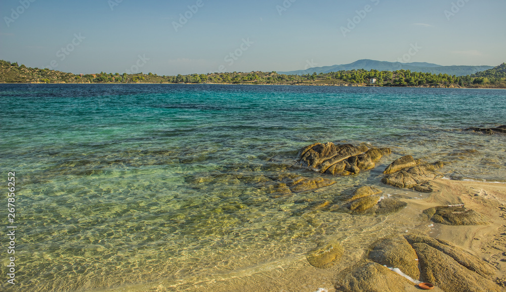 picturesque wild sand Greece beach scenery landscape of Aegean sea lagoon with shallow green and blue water  