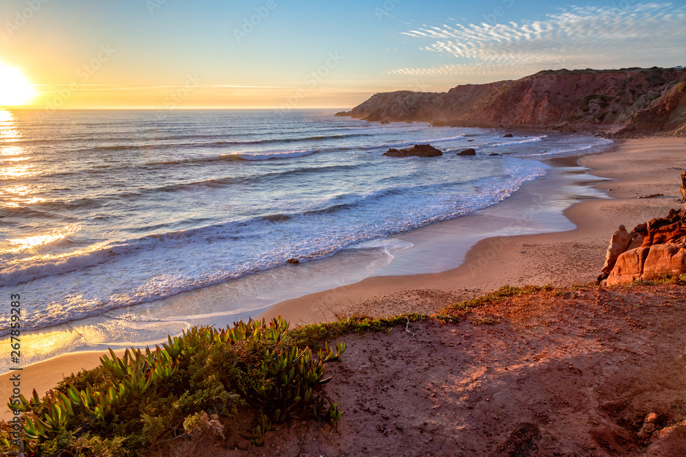 Sunset at Praia do Amado in the Costa Vicentina natural park at the Atlantic Ocean at the Algarve, Portugal. Sunset at Praia do Amado in the Costa Vicentina natural park at the Atlantic Ocean at the Algarve, Portugal.
