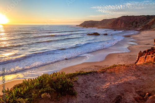 Sunset at Praia do Amado in the Costa Vicentina natural park at the Atlantic Ocean at the Algarve, Portugal.