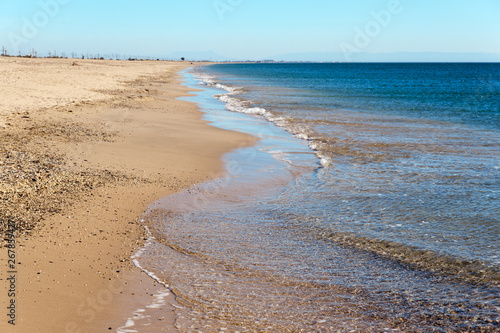 Calm soft waves roll on the sandy beach