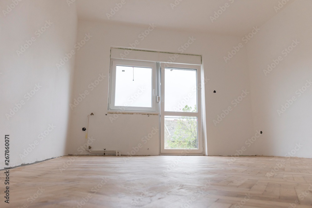renovation of the house.white empty room with parquet and pvc windows. renovation of the house.white empty room with parquet and pvc windows.