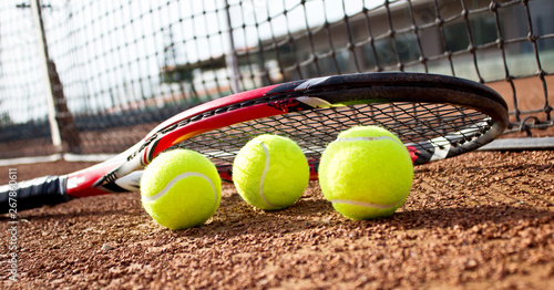 Tennis racket and balls on the clay tennis court. Close up. © Betl