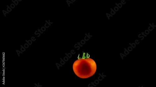tomatoes falling down from above in slow motion in the water