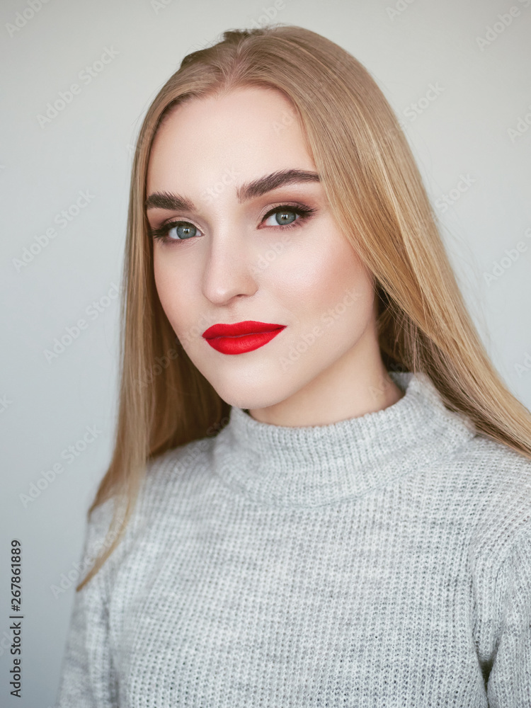 Closeup natural light beauty portrait of blonde woman model with vibrant saturated red lips bright lips makeup, cheekbones and healthy shiny skin. Closeup natural light beauty portrait of blonde woman model with vibrant saturated red lips bright lips makeup, cheekbones and healthy shiny skin.