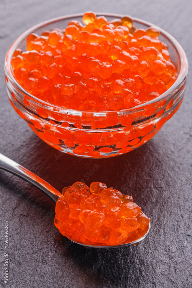 red caviar in a bowl on a dark stone background red caviar in a bowl on a dark stone background
