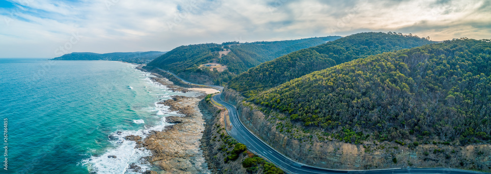Great Ocean Road passing through scenic landscape in Victoria, Australia - aerial panoramic landscape