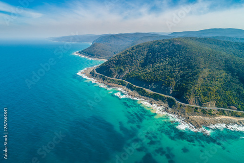 Aerial landscape of Great Ocean Road and scenic green hills on sunny day in Victoria, Australia