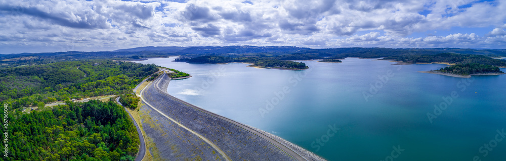 Wide aerial panorama of Cardinia Reservoir lake and dam wall surrounded by forests in Melbourne, Australia